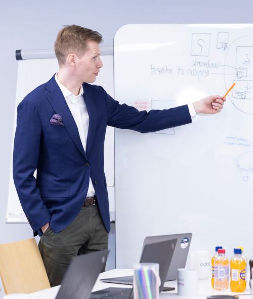 talousjohtaja esittelee asiaa whiteboardilla